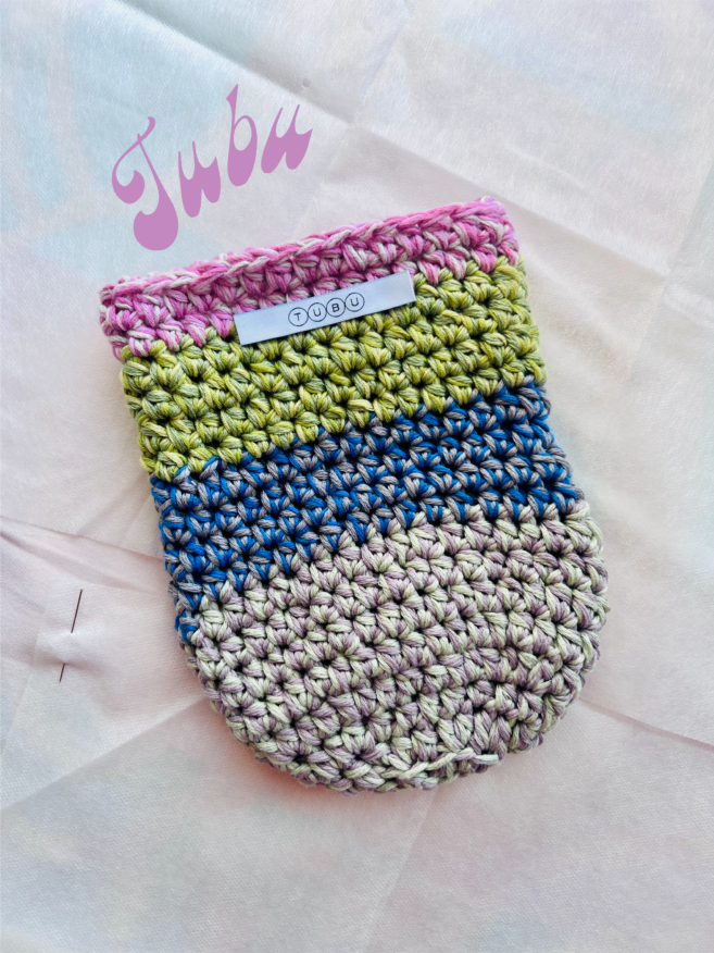 Multicolored crocheted bag in pink, green, blue and grey.