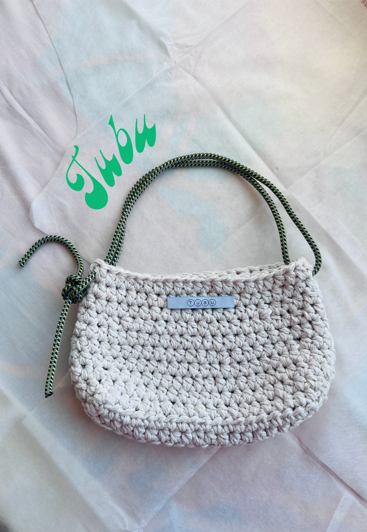 Small white crocheted bag with a climbing rope as handle.